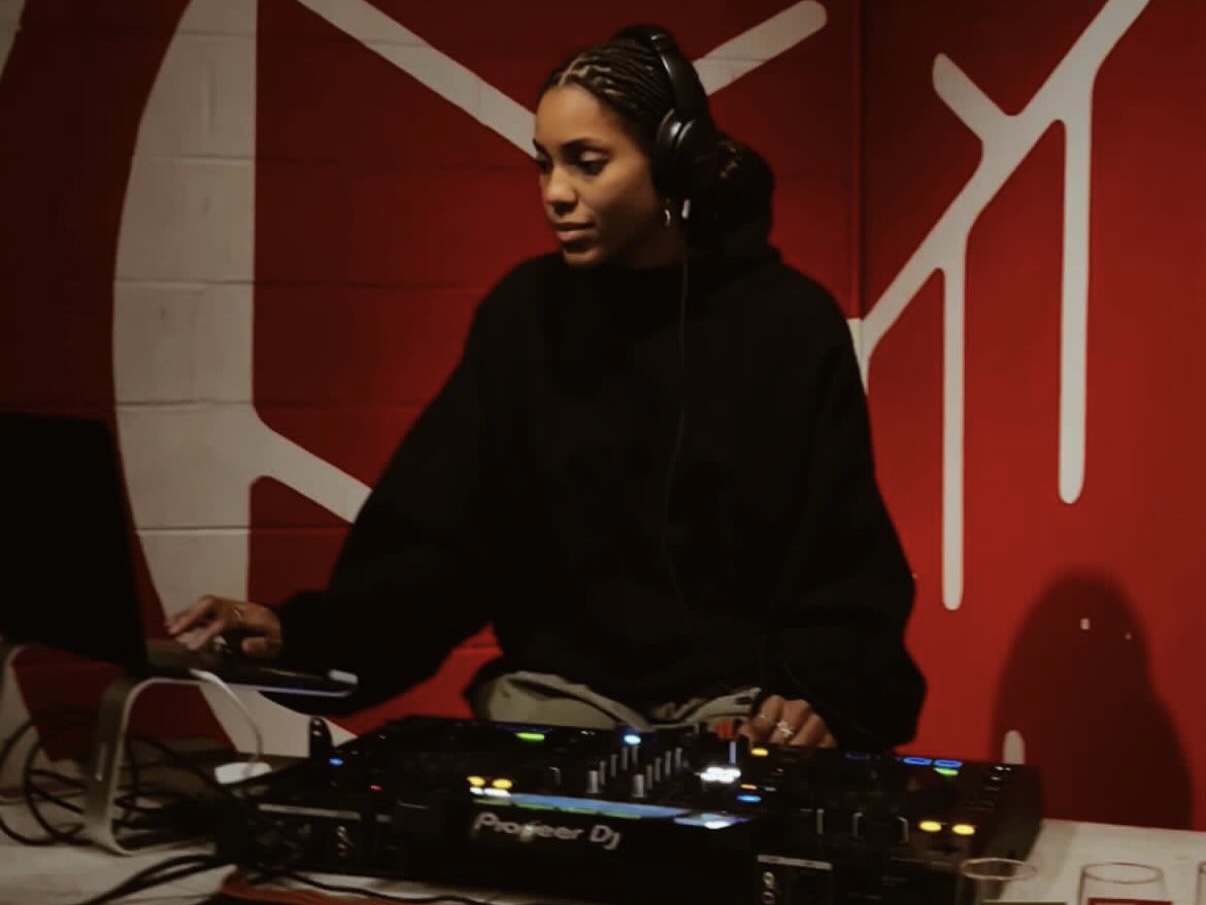 Daniella sitting with a DJ controller.